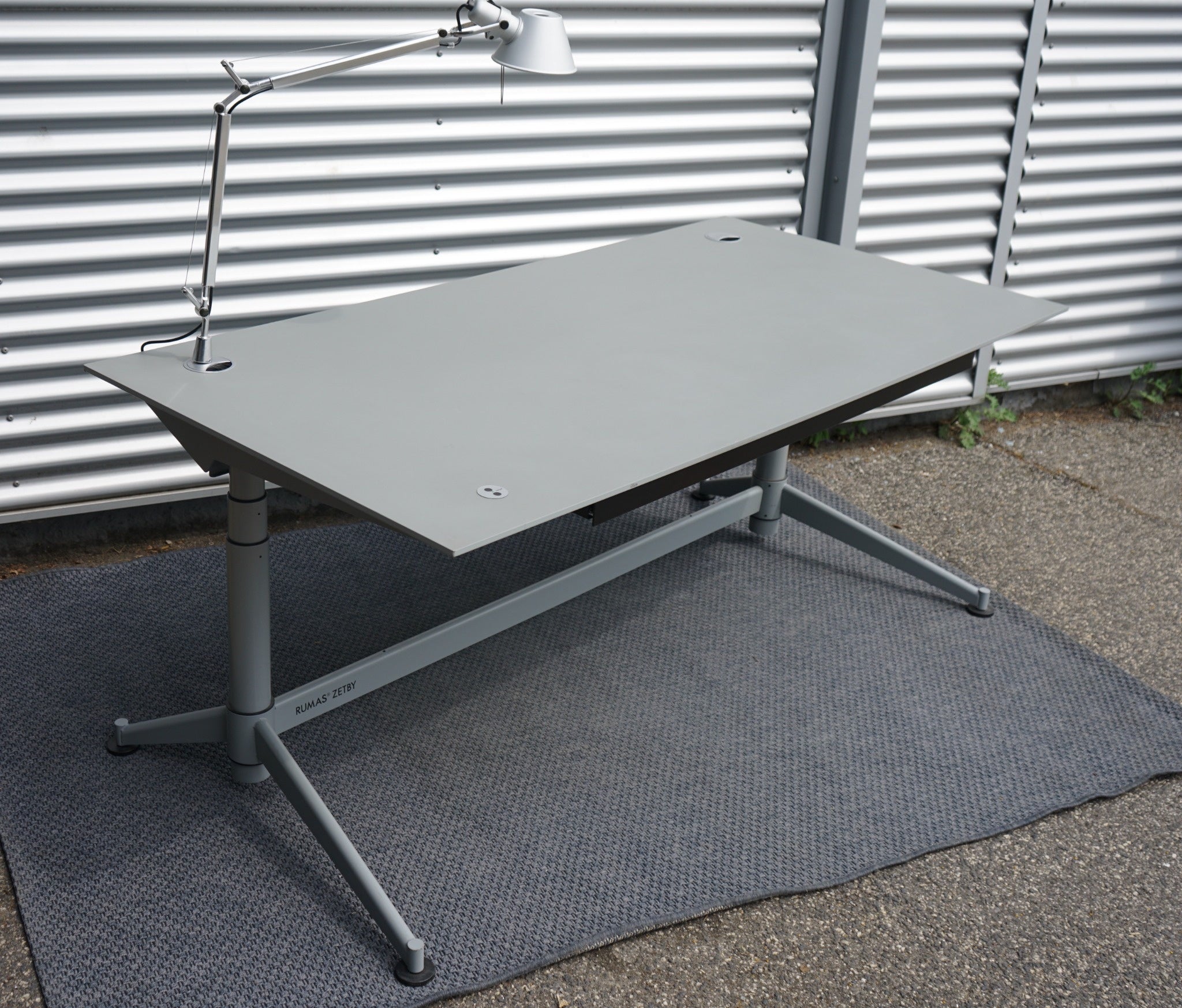 Rumas Zetby hæve-/sænkebord 180x90 cm i grå set fra skrå vinkel med kabelskjuler og stilrent design